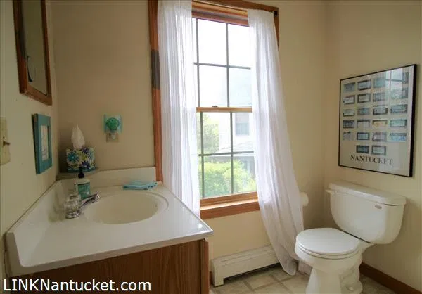 Bathroom with vanity, toilet and window