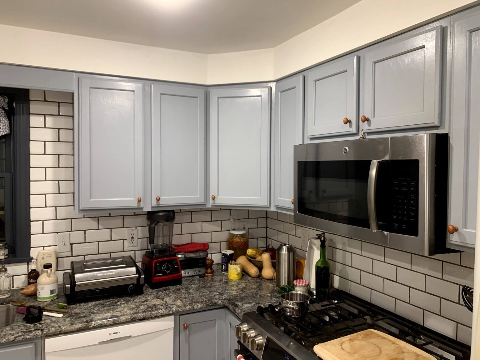 Kitchen with light blue cabinets, subway tile backsplash and stainless appliances